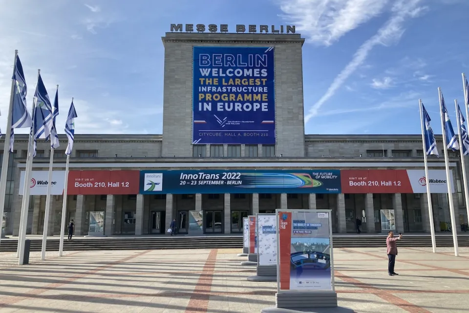 Banner welcoming Polish transit hub project at convention center in Berlin.